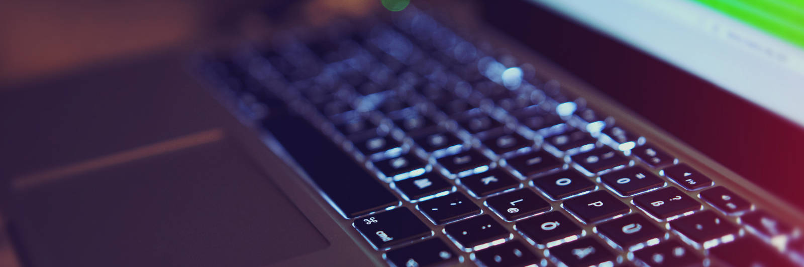 Image of a MacBook Pro with backlit keyboard in the dark